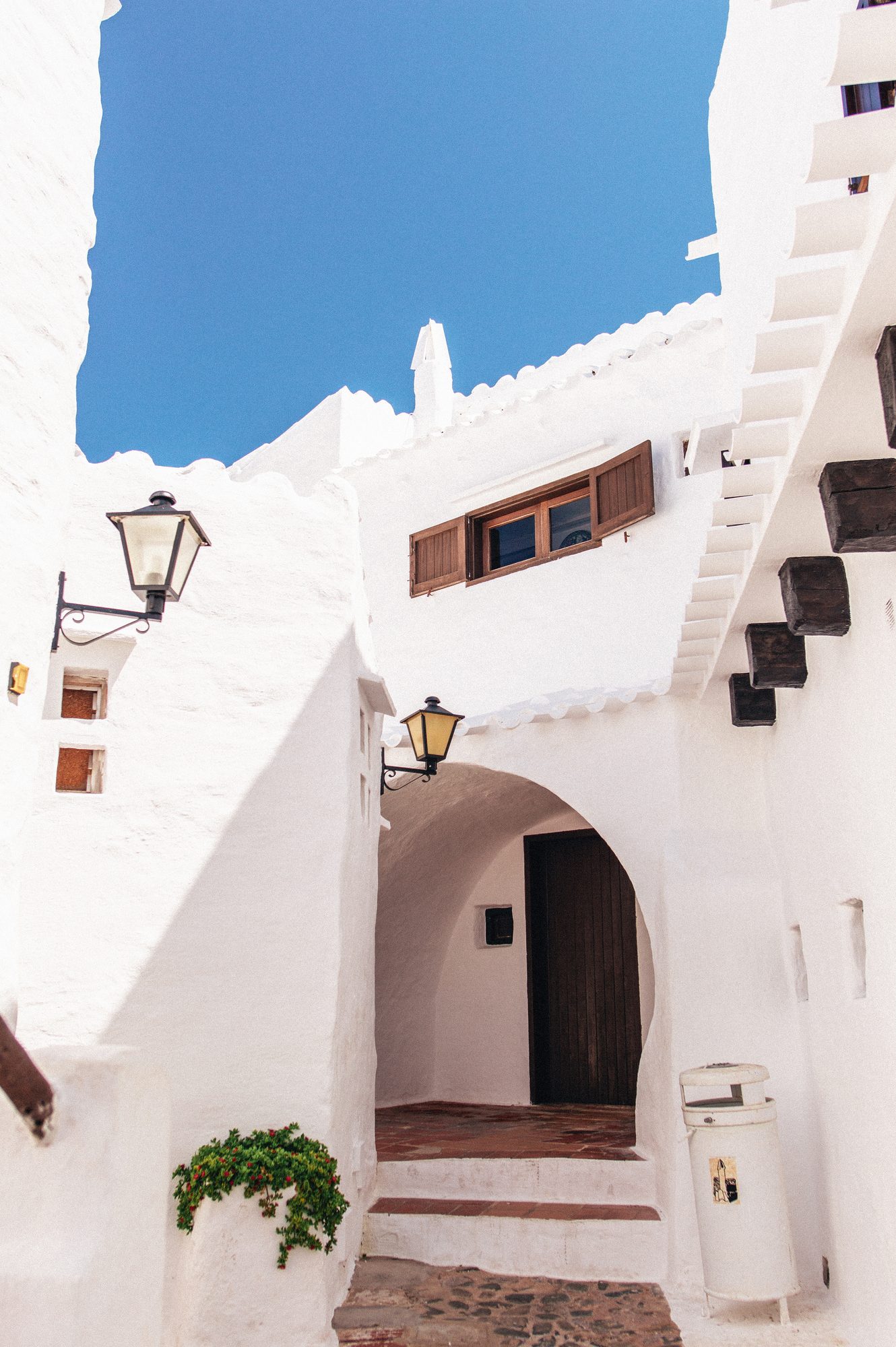Whitewashed walls and a lantern against a deep blue sky