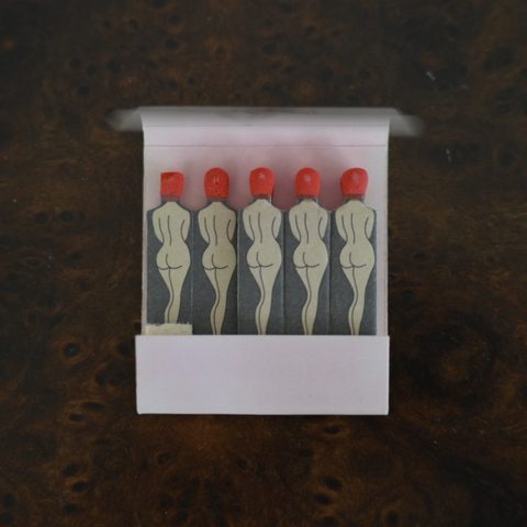 Delilah matchbook opened, five matches each printed with a nude figure seen from behind